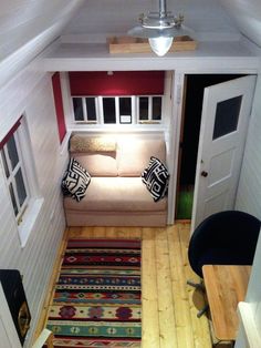 an overhead view of a small living room with a couch and rug on the floor