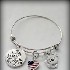 a silver bracelet with an american flag and a teddy bear charm on it that says, lord protect him while he protects us