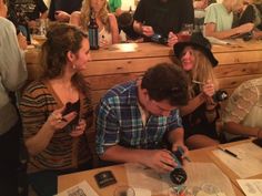 a group of people sitting at a table with papers and wine bottles in front of them