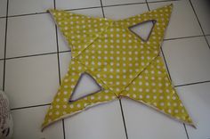 a yellow and white polka doted star laying on the floor next to a pair of shoes