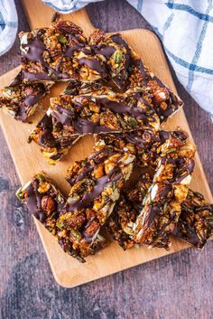 homemade granola bars with chocolate drizzled over them on a cutting board