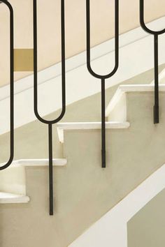 a set of stairs with black metal handrails next to each other on concrete flooring