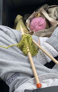 two knitting needles are laying on the back of a car seat