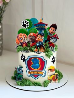 a birthday cake decorated with the characters of paw patrol on it's top tier