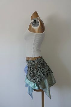 One of a Kind Size Small/Medium Elastic lace waistband Hand draped skirt Synthetic spandex fabric Mid-Low waist Model is 5’8, 32A Bust, Waist 26, Hips 38.5 Sizing Measurements in Inches Below Waist 26-28”, Hips 36-41”, Inseam Length 16” Up-cycled from two shirts, thrifted fabric, and a skirt *these skirts are all handmade and hand draped (not patterned) the prices reflect the time it took to create them. We try and price them as fairly as possible. You aren’t just purchasing a skirt you are purc