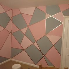 a room with pink and grey wallpaper on the walls