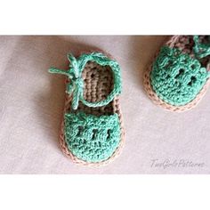 two crocheted baby shoes sitting on top of a bed