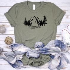 NOTE - ONLY XL  IS AVAILABLE IN PURPLE AT THIS TIME. This cute mountains scene tshirt is a must. We use a high-quality unisex t-shirt that is insanely soft. In fact, it will be one of the softest, best fitting, most comfortable shirts you’ve ever owned.Our shirts are handmade in Ohio by hand with love and care one at a time.We hope you will find a shirt that will inspire you or someone else.DON'T SEE A COLOR OF SHIRT YOU LIKE, FEEL FREE TO CONTACT ME VIA EMAIL AND I WILL DO MY BEST  TO ACCOMMODA Graphic Tee T-shirt With Crew Neck For Hiking, Green Shirt For Summer Outdoor Activities, Crew Neck T-shirt With Letter Print For Hiking, Pre-shrunk Graphic Tee For Hiking, Green Letter Print T-shirt For Camping, Graphic Tee For Hiking With Relaxed Fit, Green Graphic Print T-shirt For Camping, Relaxed Fit Graphic Tee For Hiking, Green Graphic Tee For Outdoor Activities