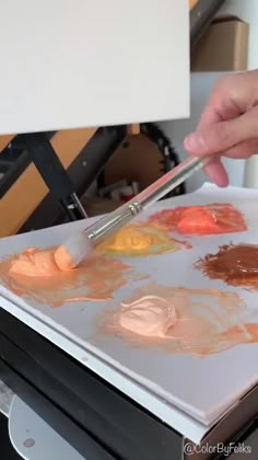 a person is painting on an easel with paint