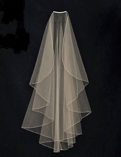 the veil is white and has ruffles on it, as well as black background