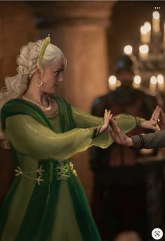 game of thrones screenshote with two women in green dresses, one holding the hand of another woman