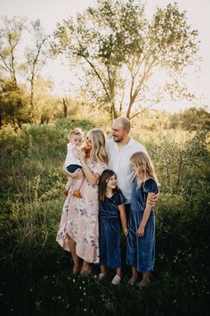 a family poses for a photo in the grass