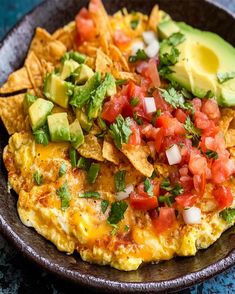 an omelet with tortilla chips, tomatoes and avocado