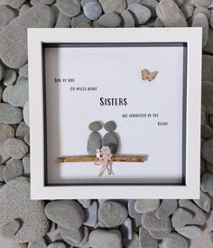 a white frame with some rocks and a small stuffed animal on it's side