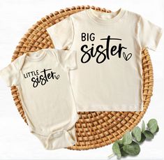 two baby onesuits with the words big sister and little sister printed on them