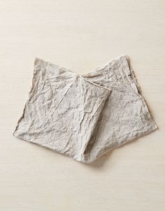 two folded napkins sitting on top of a wooden table