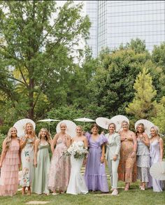 a group of women standing next to each other in dresses and holding umbrellas over their heads