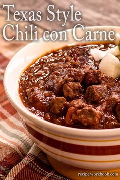 a bowl filled with chili and meat on top of a table