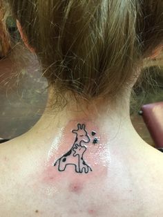 a giraffe tattoo on the back of a woman's neck