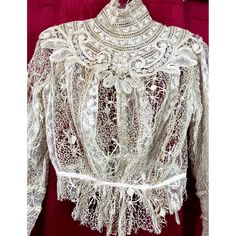 C 1900 blouse with fancy crochet and tatting. The lining is gone in the bodice and in the sleeves it is still present, but it is tearing and shredding. I would recommend removing this also around the waist.  The color of this is actually ecru, not white. It just looks more white because of the red backdrop. Bust 42. waist 26. Victorian Lace Blouse With Lace Trim, Victorian Lace Trim Formal Tops, Vintage Lace Patchwork Blouse For Wedding, Victorian Lace Work Blouse For Wedding, Victorian Lace Wedding Blouse, Vintage Lace Blouse With Lace Work, Vintage White Blouse With Crochet Lace, Vintage White Crochet Lace Blouse, White Vintage Blouse With Crochet Lace