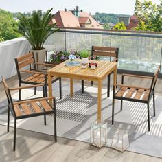 an outdoor table and chairs on a deck with potted plants in the corner next to it