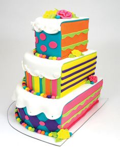 a multi - layered cake with polka dots and flowers on the top is decorated in bright colors