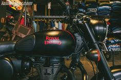 the royal enfield motorcycle is parked in front of other motorcycles and luggage on display at an antique store