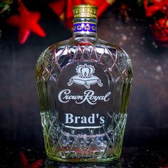 a bottle of crown royal brand's brandy sitting on a table next to christmas decorations