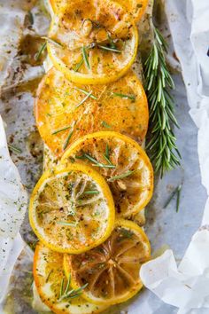 sliced lemons and rosemary on top of parchment paper