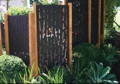 a wooden fence surrounded by lush green plants