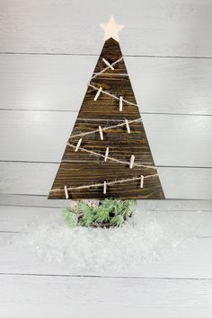 a wooden christmas tree with clothes pins on it