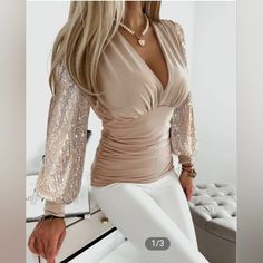 Gift This New Elegant Blouse Or Keep It For Yourself! This Light Sand-Colored Blouse With Contrast Sequin On The Sleeves And A Plunging Neckline Can Be Worn Casually With A Pair Of Jeans Or For Work By Wearing It With A Pencil Skirt & A Camisole Underneath. Pit-To-Pit Is Approx. 18" Sleeve Length Is Approx. 24" Waist Is Approx. 26" Length Is Approx. 25 & 3/4" Bust Is Approx. 33" Material: 97% Polyester/ 3% Spandex (Photo Credit: Chic Me) 2023 Clothing, Belle Silhouette, Autumn 2023, Straight Dress, Outfit Casual, Lantern Sleeves, Middle Age, Amelie, Top Casual