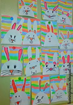 some bunny paintings are hanging on the wall in front of a door with colorful stripes