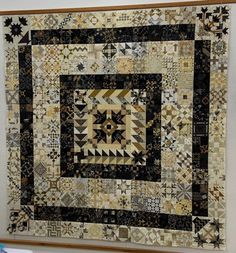 a large quilt hanging on the wall next to a wooden frame with an image of a star