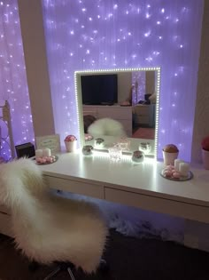 a white desk with a mirror and lights on it in front of a purple wall