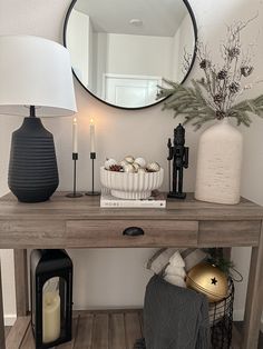 a wooden table topped with a mirror next to a lamp