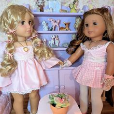 two dolls standing next to each other in front of a shelf with toys on it