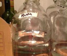 two empty glass bottles sitting on top of a wooden table next to boxes and corkscrews