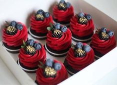 red velvet cupcakes decorated with blueberries and blackberries in a white box