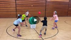 several children are playing with a ball on a basketball court