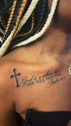 the back of a woman's shoulder with a cross and bible tattoo on it