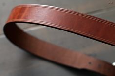 "These every day leather belts are made using thick, durable, full-grain harness leather from the Wickett & Craig tannery. Designed to be at your service for many years, they will take on a wonderful rich character with age. They're 1.5\" in width, with a tapered, low profile tail-end. Its hand-stitched construction is fitted with a solid brass buckle with a muted, satin-steel finish. For added comfort and durability, all edges are rounded and burnished smooth with a soft wax finish. Handcra Brown Bridle Leather Belts And Suspenders For Everyday, Classic Bridle Leather Belts For Everyday Use, Brown Leather Strap Belt Buckle For Everyday Use, Brown Leather Belt Buckles For Everyday Use, Rich Character, Custom Leather Belts, Pet Name Tags, Handmade Guitar, Leather Craftsmen