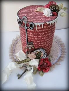 a red hat decorated with flowers and keys on top of a white table topped with ribbon