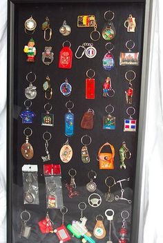 a shadow box with many different keychains and medals in it on a white sheet