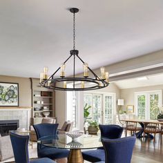 a dining room table with blue chairs and a chandelier hanging from the ceiling