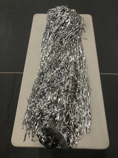 a pile of silver tinsel sitting on top of a white cutting board