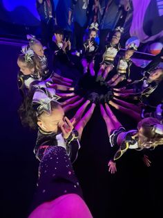 a group of people standing around each other in front of a purple and blue background