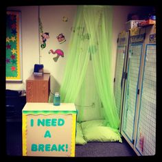 a room with green curtains and a sign that says i need a break on the floor