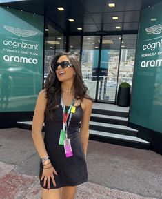 a woman wearing sunglasses standing in front of a building