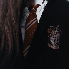 a man with long hair wearing a harry potter tie